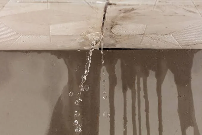 Water leaking through a damaged ceiling